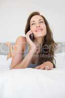 Pretty relaxed woman using mobile phone in bed