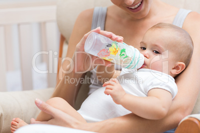 Mother feeding baby with milk bottle