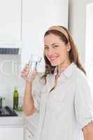 Portrait of a woman drinking water in kitchen