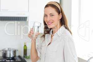 Portrait of a woman drinking water in kitchen