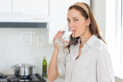 Portrait of a woman drinking water in kitchen