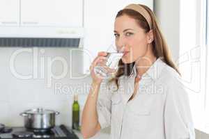 Portrait of a woman drinking water in kitchen