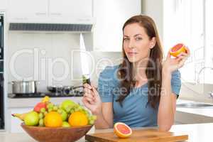 Woman with fruit bowl on counter in kitchen