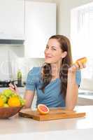 Woman with fruit bowl on counter in kitchen