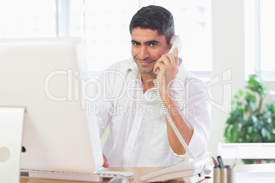 Businessman using telephone and computer