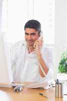 Businessman using landline phone and computer