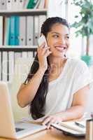 Businesswoman using cell phone at desk