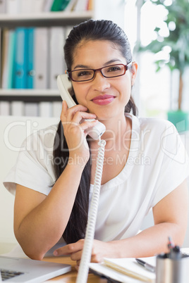 businesswoman using landline phone in office