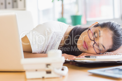 Overworked businesswoman sleeping on desk