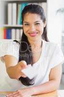 Confident businesswoman offering business card