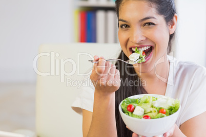 Happy businesswoman eating healthy salad