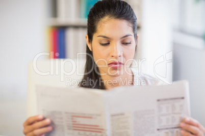 Businesswoman reading newspaper