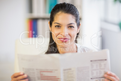 Portrait of businesswoman reading newspaper