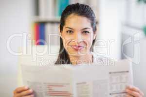 Portrait of businesswoman reading newspaper