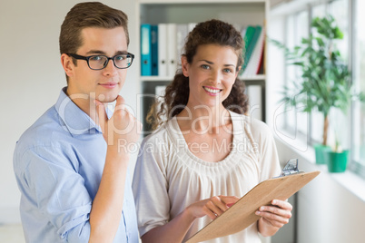 Confident business people with clipboard