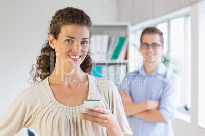 Confident businesswoman holding mobile phone