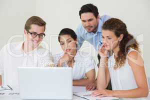 Business people looking at laptop