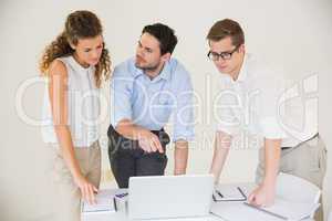 Business people discussing over laptop