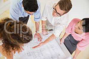 Business people discussing over blueprint