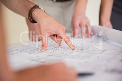 Businessman pointing on blueprint