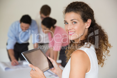 Confident businesswoman holding digital tablet