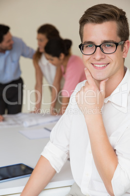 Happy businessman with hand on chin