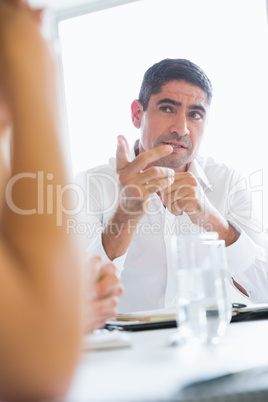 Confident businessman pointing at colleague