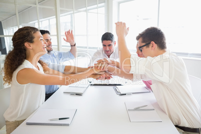 Businessteam stacking hands at table