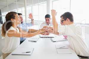 Businessteam stacking hands at table