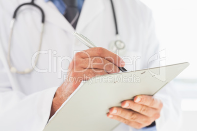 Doctor writing on clipboard