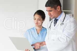 Doctor showing laptop to nurse