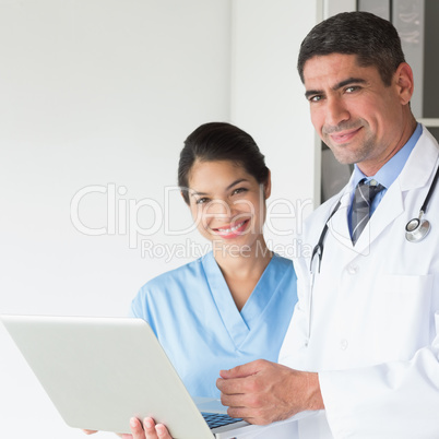 Confident doctor and nurse using laptop