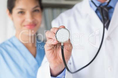 Midsection of doctor holding stethoscope