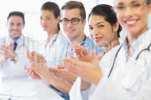 Confident nurse and doctors applauding