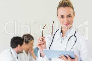 Doctor holding digital tablet and glasses