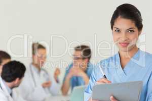 Female nurse writing on clipboard