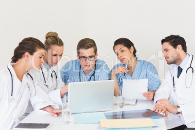 Doctors and nurses discussing over laptop