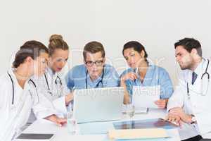 Doctors and nurses discussing over laptop