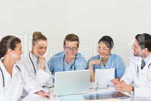 Medical team discussing over laptop