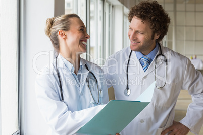 Happy doctors discussing over file