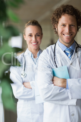 Happy doctors standing arms crossed