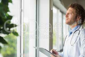 Thoughtful doctor with clipboard
