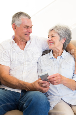 Loving couple holding mobile phone
