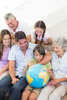 Multigeneration family looking at globe