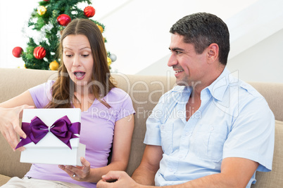 Surprised woman opening Christmas present