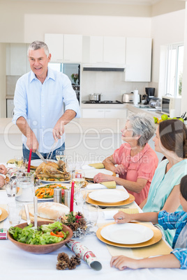 Senior man serving meal to family