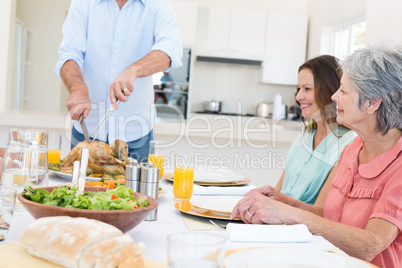 Senior man serving food to family