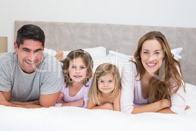 Smiling family in bed