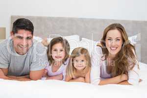 Smiling family in bed