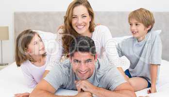 Happy parents and children in bed